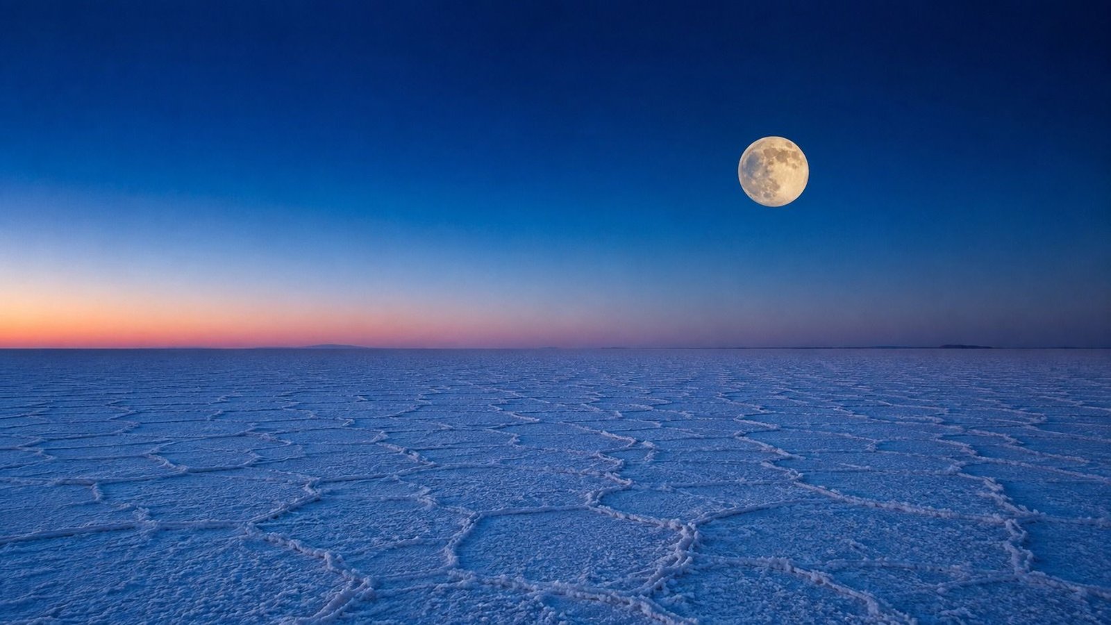 The white salt flats of the Rann of Kutch under a full moon at dusk, Gujarat