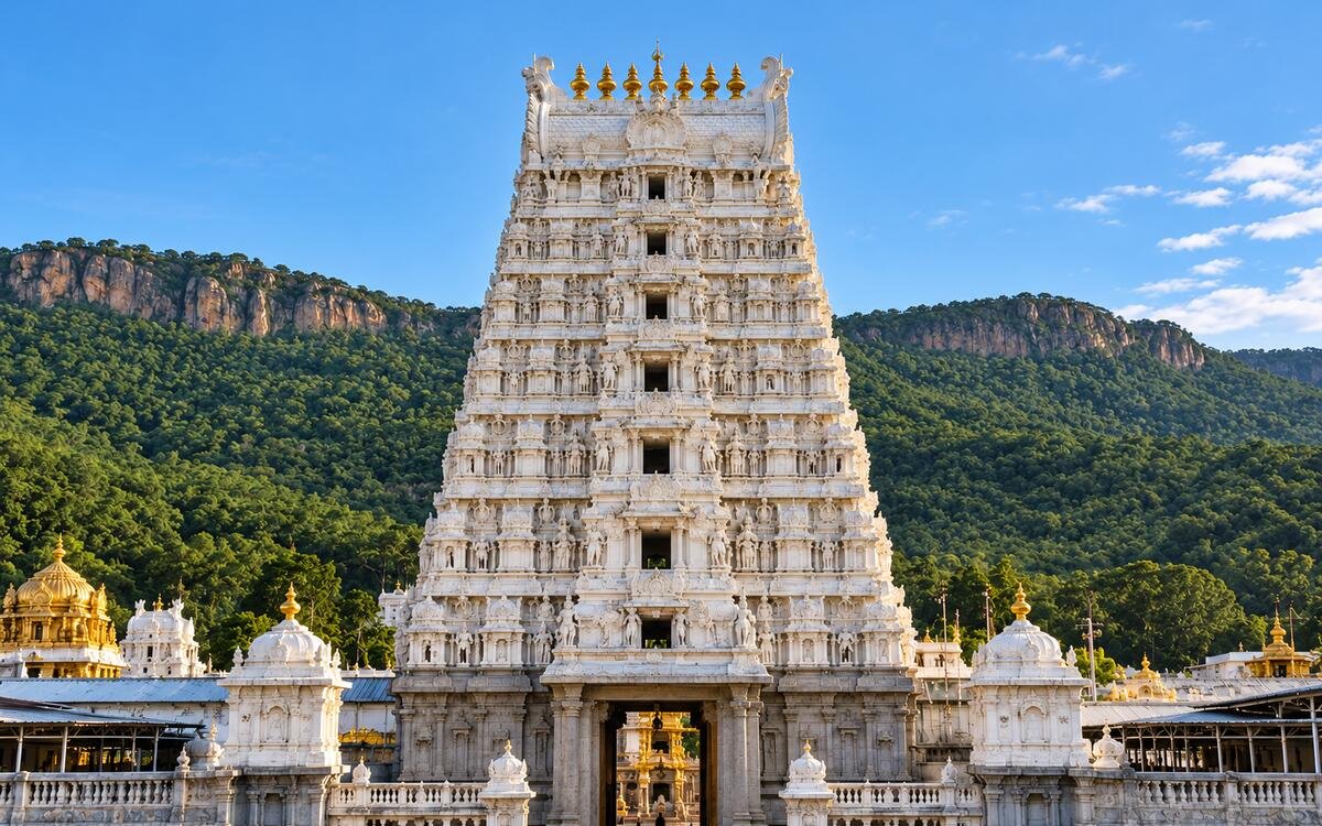 A carved South Indian temple gopuram against the Tirumala hills at Tirupati, Andhra Pradesh