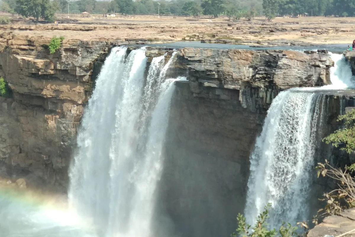 Chitrakote Falls seen from the rock ledge above the plunge pool, a rainbow in the spray
