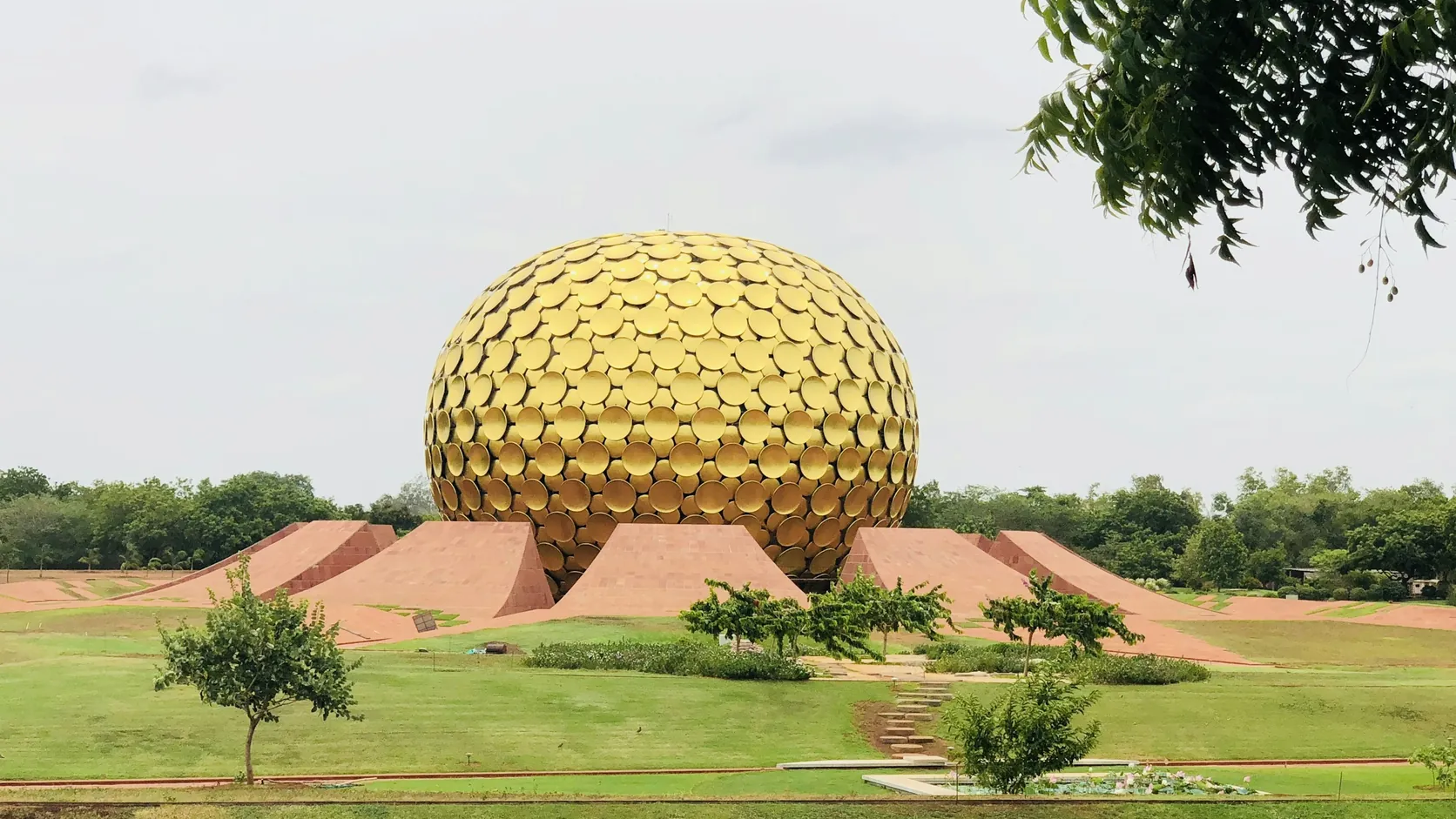The golden Matrimandir sphere seen across the gardens at Auroville near Pondicherry