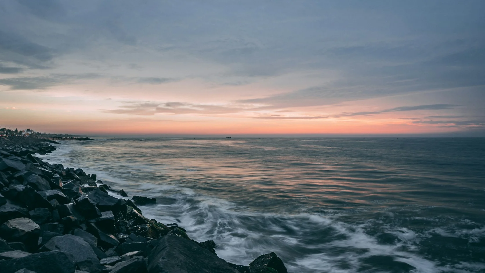 Waves breaking over the rock armour along the Pondicherry seafront at dawn
