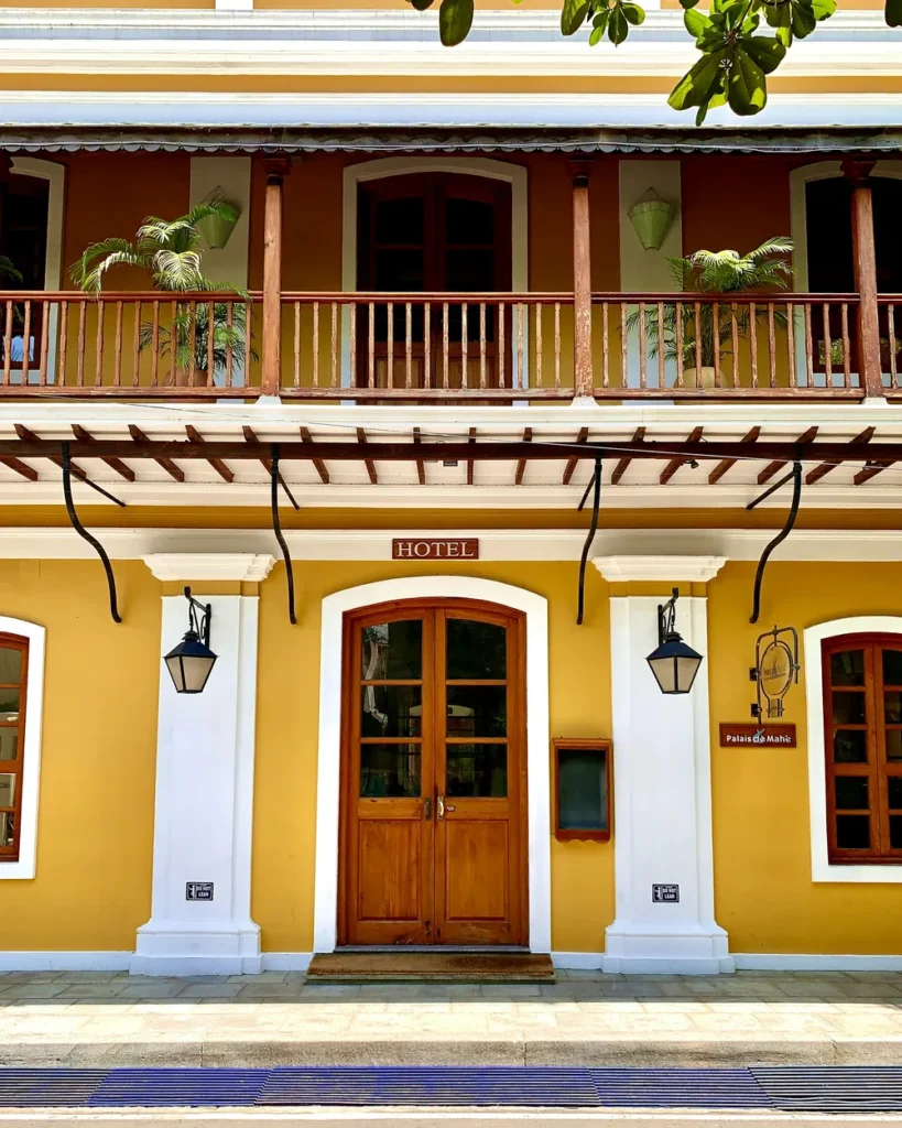 Mustard-yellow colonial facade with wooden doors and a verandah in White Town, Pondicherry