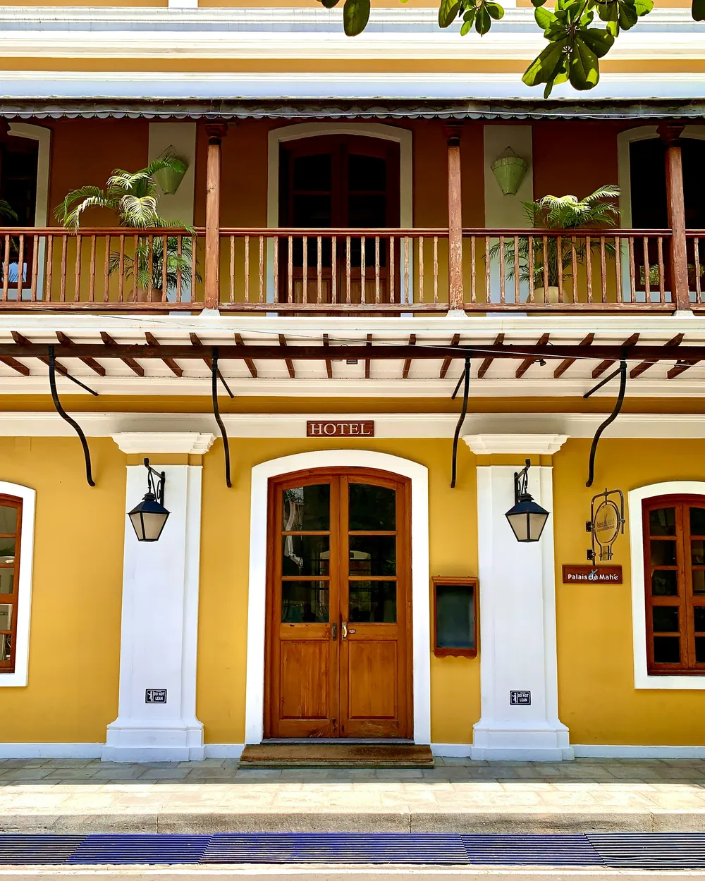 Mustard-yellow colonial facade with wooden doors and a verandah in White Town, Pondicherry
