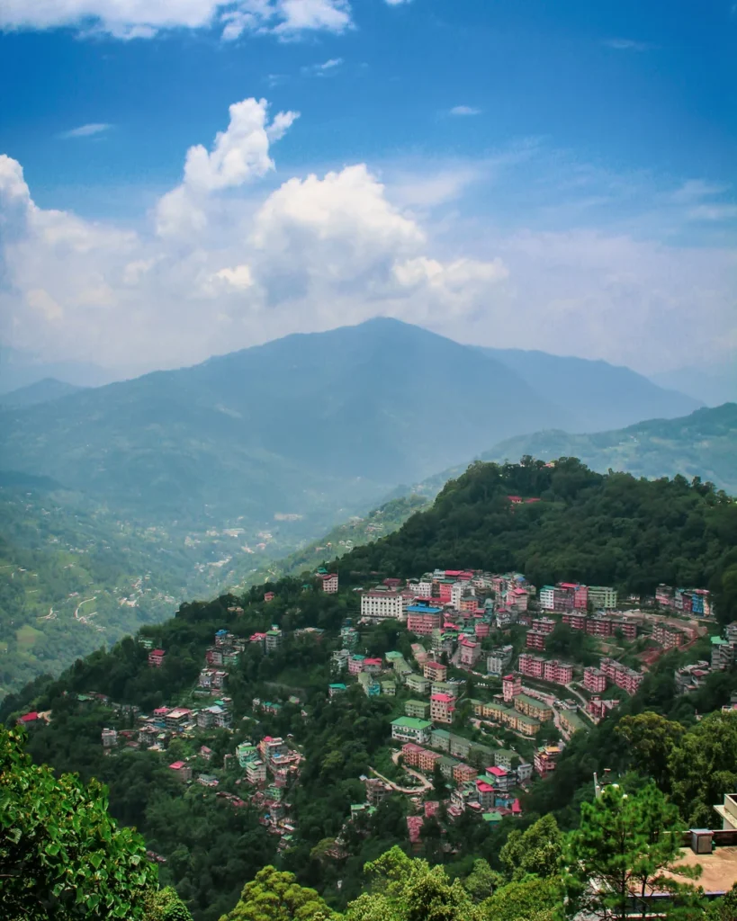 A hill town spread along a ridge with layered Himalayan ranges behind, Sikkim